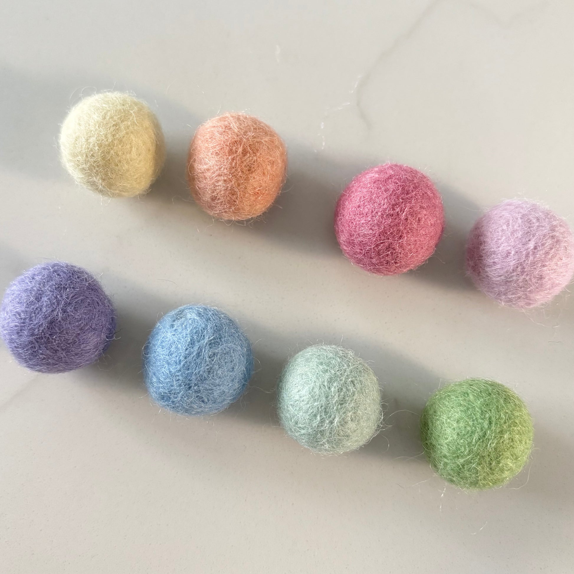 Set of colorful felt balls on a light gray background