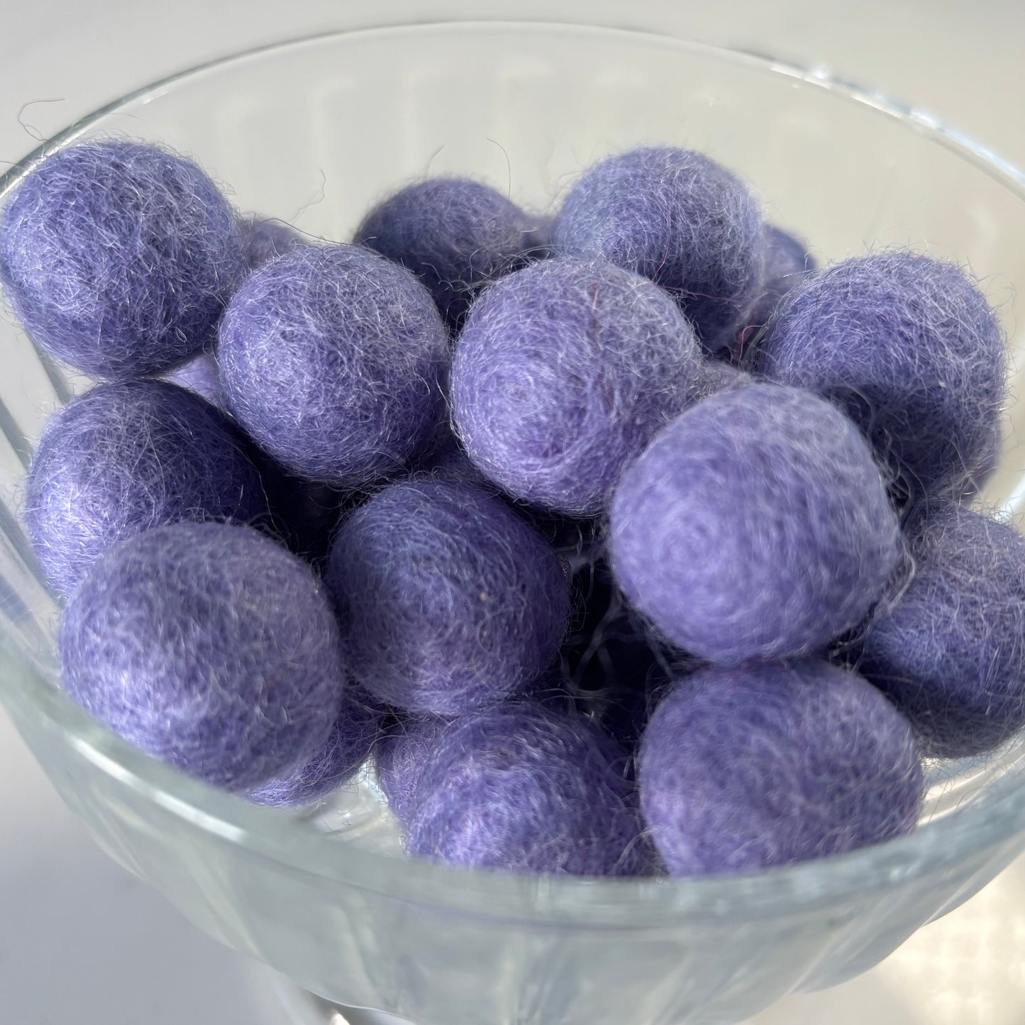 Purple felt balls in a glass bowl