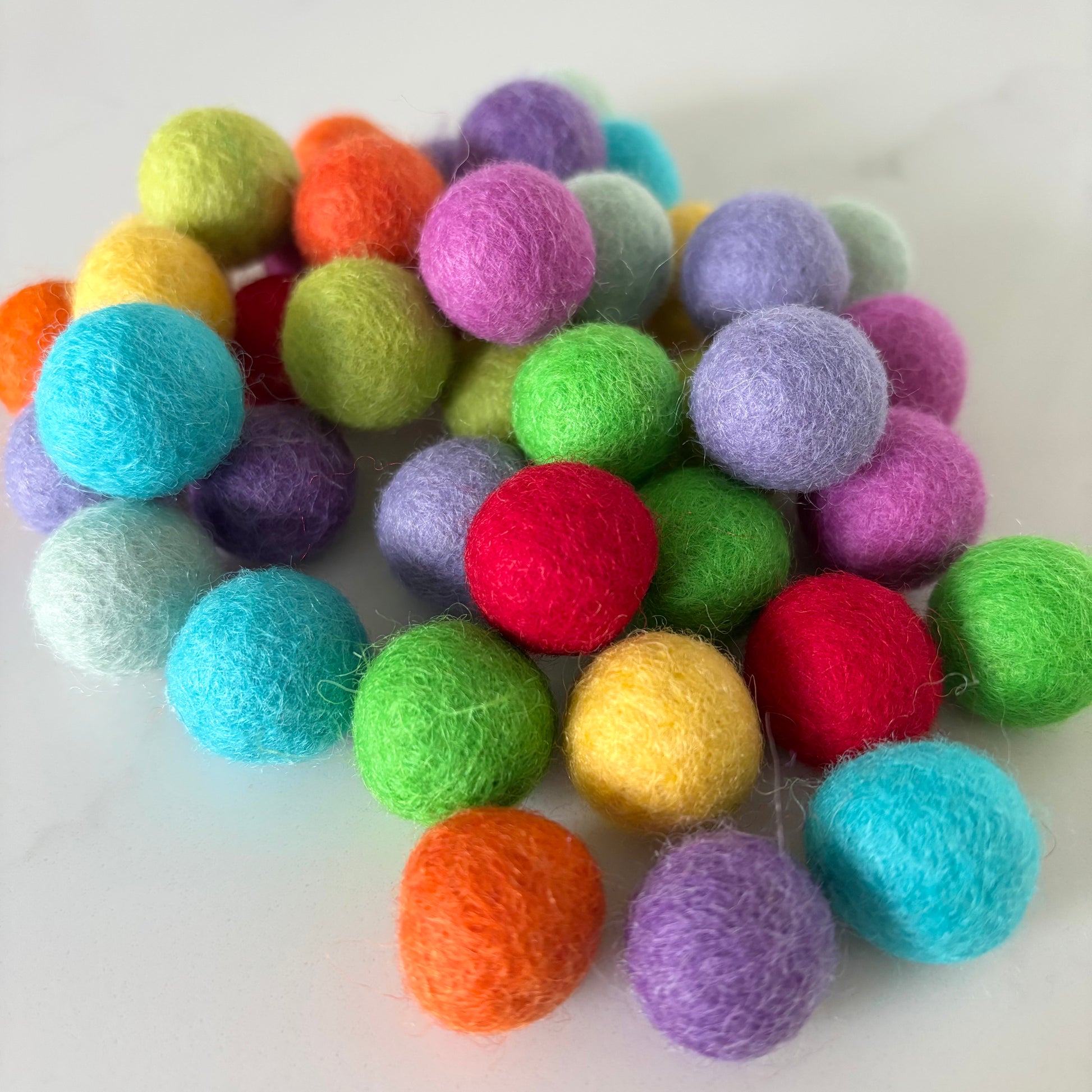 Assorted colorful felt balls on a white background